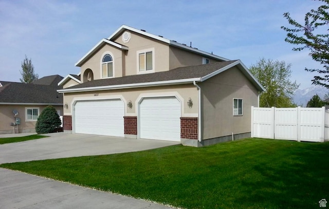 view of front of home with driveway, fence, a front yard, a garage, and brick siding