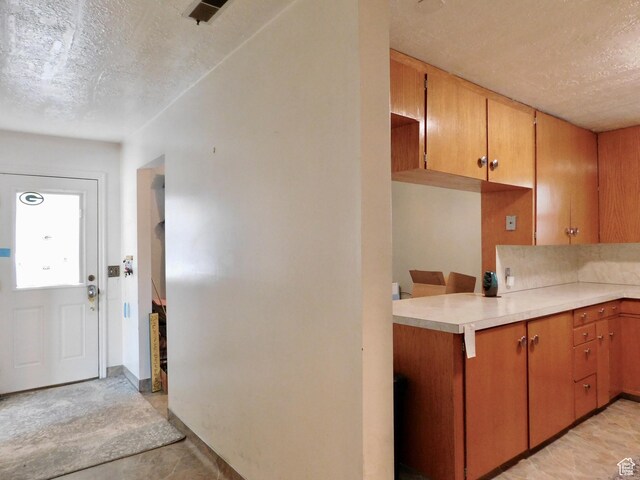 1660 W 700 S, Marriott Slaterville, UT 84404 - kitchen featuring brown cabinets, visible vents, light countertops, and a textured ceiling