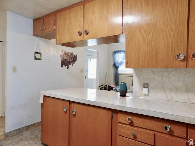 1660 W 700 S, Marriott Slaterville, UT 84404 - kitchen with a peninsula, brown cabinets, light countertops, and backsplash