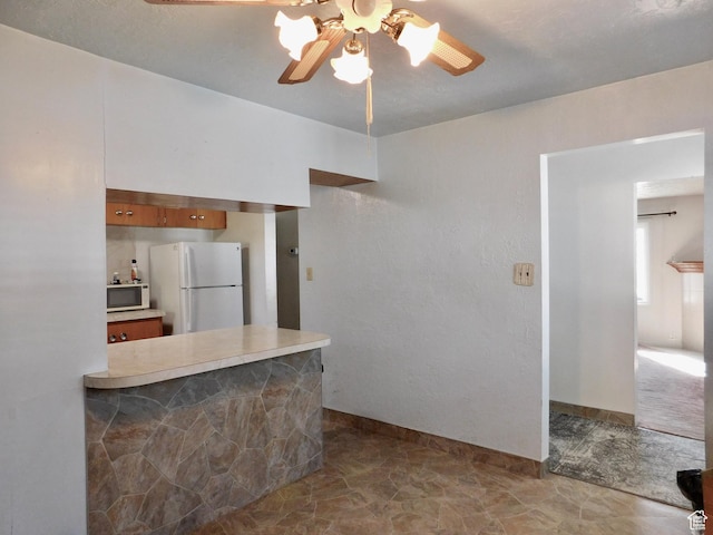 1660 W 700 S, Marriott Slaterville, UT 84404 - kitchen with light countertops, brown cabinetry, ceiling fan, white appliances, and a peninsula