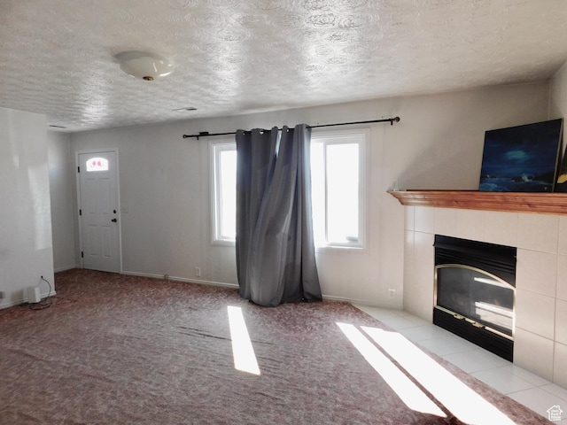 1660 W 700 S, Marriott Slaterville, UT 84404 - unfurnished living room featuring a textured ceiling, a tiled fireplace, carpet flooring, and baseboards