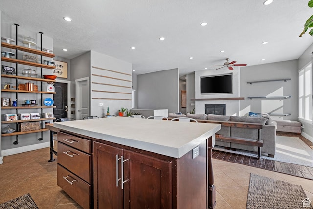 1137 S 925 E, Salem, UT 84653 - kitchen featuring tile patterned flooring, a center island, light countertops, recessed lighting, and a fireplace
