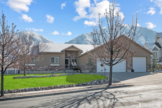 ranch-style house featuring a front yard, a mountain view, stucco siding, stone siding, and an attached garage