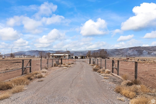view of street with a rural view, a mountain view, and driveway