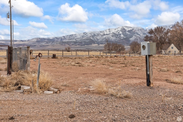 view of yard with a rural view, a mountain view, and fence