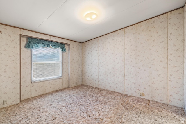 carpeted spare room with wallpapered walls