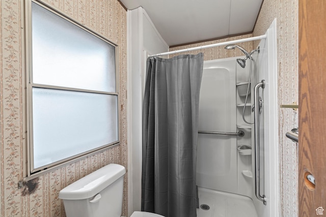 bathroom featuring curtained shower, toilet, and wallpapered walls
