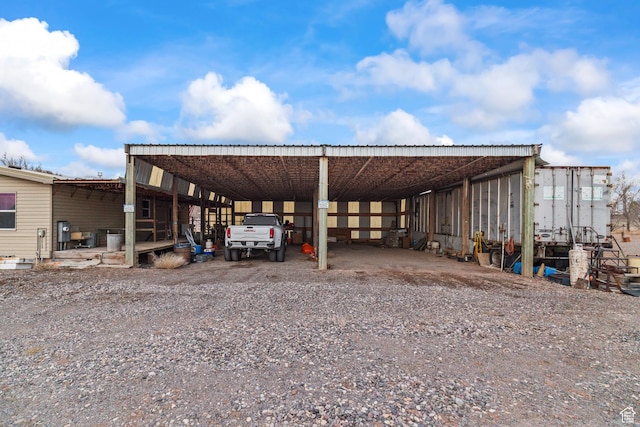 view of car parking with a carport and gravel driveway