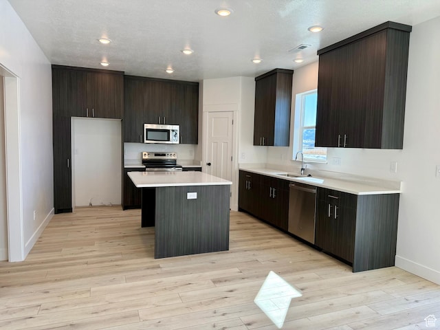 3269 S 1000 W, Nibley, UT 84321 - kitchen with visible vents, light wood-style flooring, a sink, stainless steel appliances, and a center island