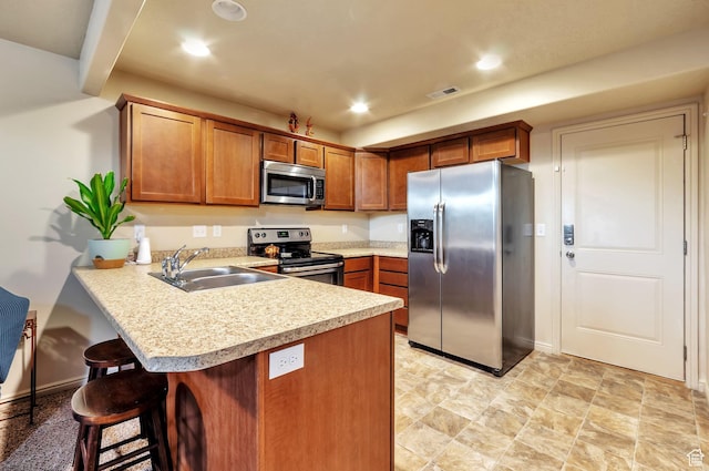 kitchen featuring visible vents, a sink, stainless steel appliances, a peninsula, and light countertops