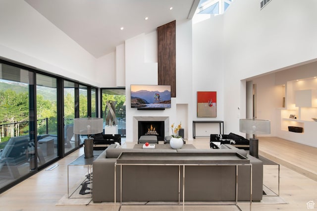 2559 Lupine Ln, Park City, UT 84060 - living area with high vaulted ceiling, wood finished floors, a warm lit fireplace, and healthy amount of natural light