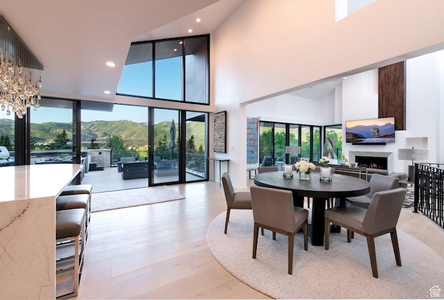 2559 Lupine Ln, Park City, UT 84060 - dining area with a warm lit fireplace, a towering ceiling, wood finished floors, a chandelier, and recessed lighting