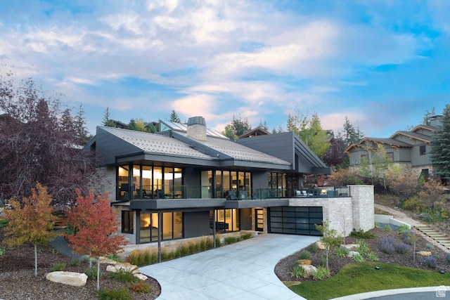 2559 Lupine Ln, Park City, UT 84060 - view of front facade featuring a balcony, concrete driveway, a standing seam roof, a garage, and a chimney