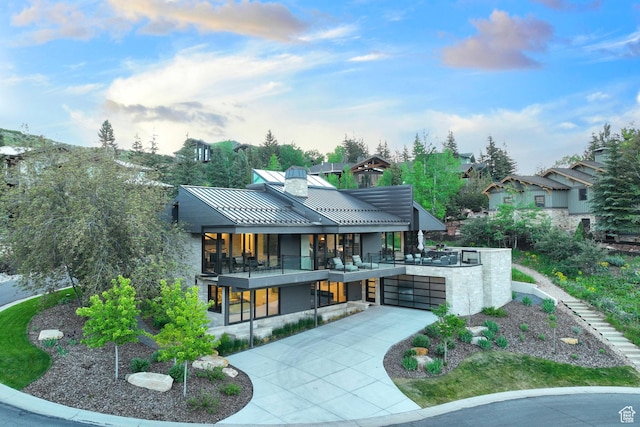 2559 Lupine Ln, Park City, UT 84060 - rear view of house with concrete driveway, a standing seam roof, a metal roof, a balcony, and a chimney