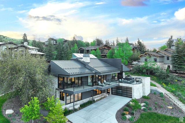 2559 Lupine Ln, Park City, UT 84060 - rear view of house with a standing seam roof, a chimney, driveway, a metal roof, and a garage