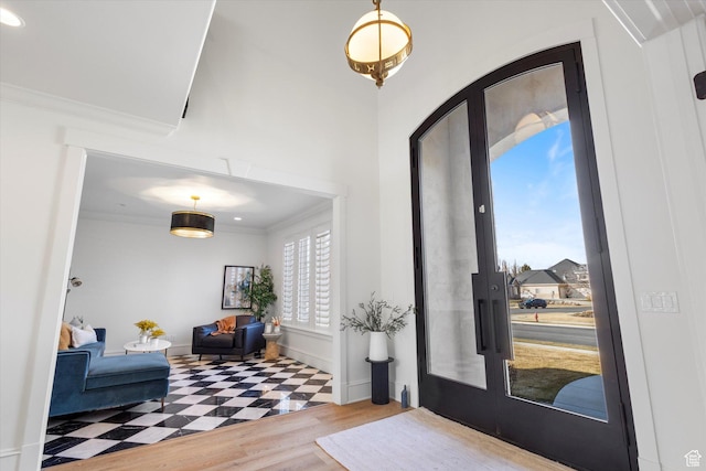 entrance foyer with baseboards, crown molding, and wood finished floors