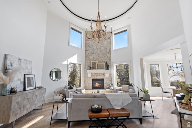 living area with a chandelier, a high ceiling, and a healthy amount of sunlight