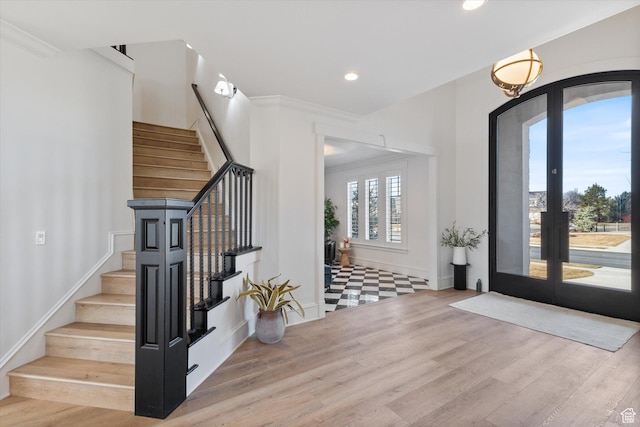 foyer entrance featuring recessed lighting, wood finished floors, stairs, and french doors