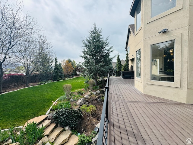 wooden terrace featuring fence and a yard