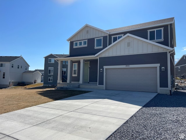 2421 S Blue Water Ln E, Saratoga Springs, UT 84045 - view of front of home featuring board and batten siding, an attached garage, covered porch, and driveway