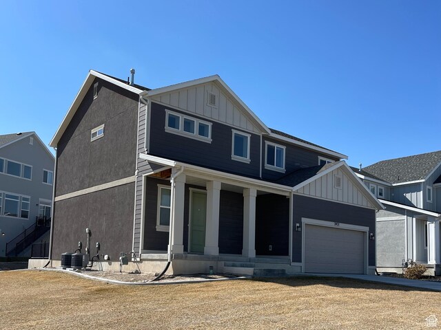 2421 S Blue Water Ln E, Saratoga Springs, UT 84045 - view of front of house with board and batten siding, an attached garage, covered porch, and driveway