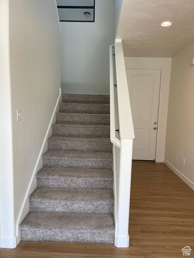 2421 S Blue Water Ln E, Saratoga Springs, UT 84045 - stairway with a textured ceiling, wood finished floors, baseboards, and recessed lighting