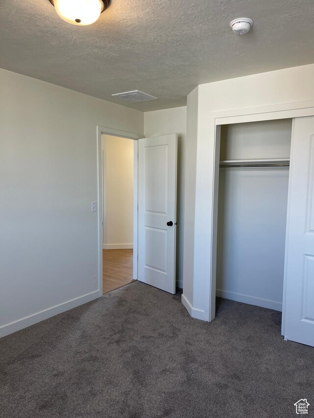 2421 S Blue Water Ln E, Saratoga Springs, UT 84045 - unfurnished bedroom with carpet floors, baseboards, a closet, and a textured ceiling