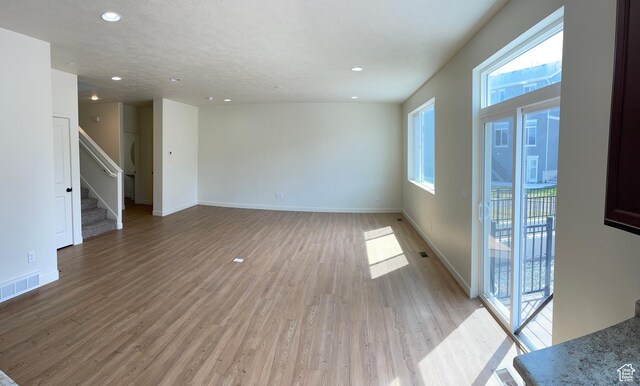 2421 S Blue Water Ln E, Saratoga Springs, UT 84045 - empty room featuring light wood-style floors, stairway, visible vents, and baseboards