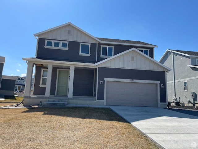 2421 S Blue Water Ln E, Saratoga Springs, UT 84045 - view of front facade with a garage, driveway, board and batten siding, and covered porch