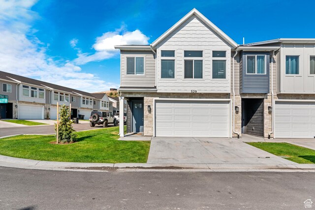 529 Richland Valley St, Garden City, UT 84028 - view of property featuring a residential view, driveway, an attached garage, and a front yard