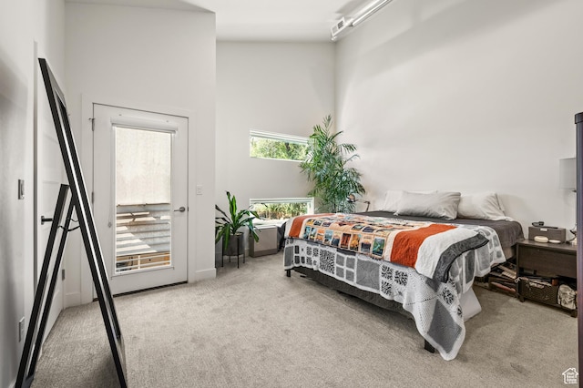 carpeted bedroom featuring a high ceiling