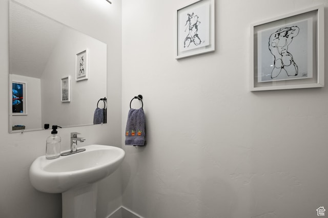 bathroom featuring a sink and vaulted ceiling