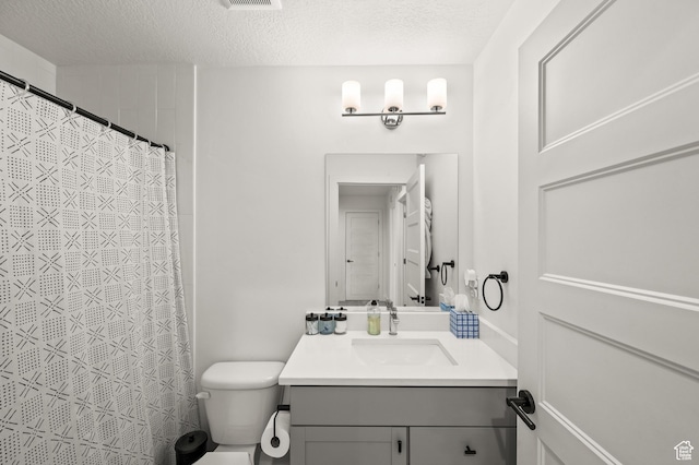 bathroom with vanity, visible vents, a textured ceiling, curtained shower, and toilet