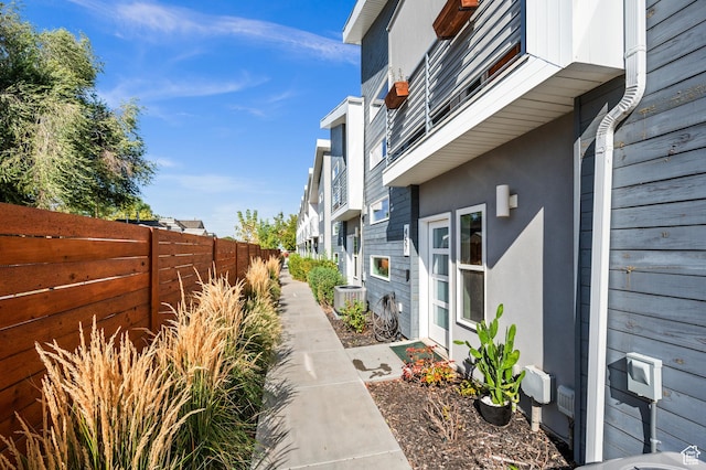 view of property exterior featuring stucco siding, cooling unit, and a fenced backyard