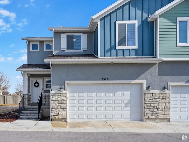3323 E Gibraltar Ave, Eagle Mountain, UT 84005 - view of front facade featuring stucco siding, stone siding, board and batten siding, and an attached garage