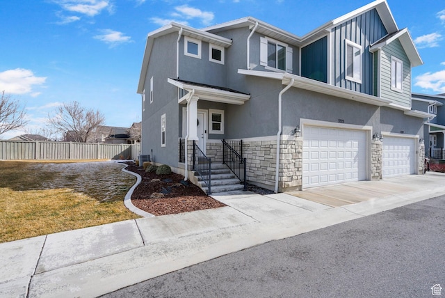 3323 E Gibraltar Ave, Eagle Mountain, UT 84005 - view of front of house with stucco siding, driveway, stone siding, fence, and a garage