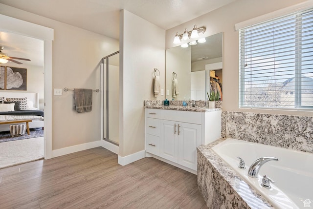 3323 E Gibraltar Ave, Eagle Mountain, UT 84005 - ensuite bathroom featuring vanity, a bath, wood finished floors, and a stall shower