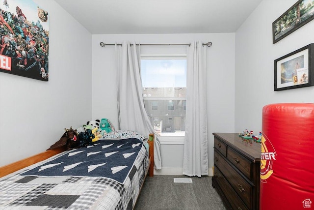 bedroom with baseboards and dark carpet