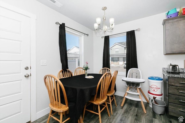 dining space with a wealth of natural light, visible vents, an inviting chandelier, and dark wood finished floors