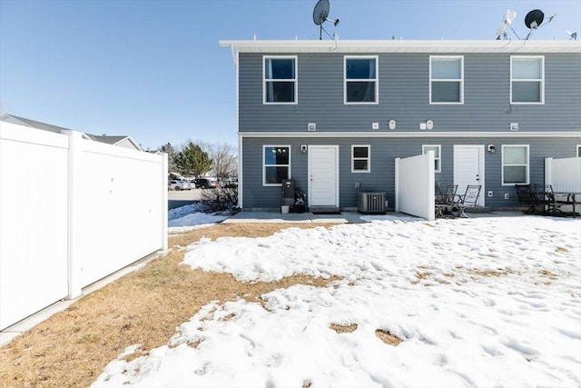 snow covered house featuring cooling unit