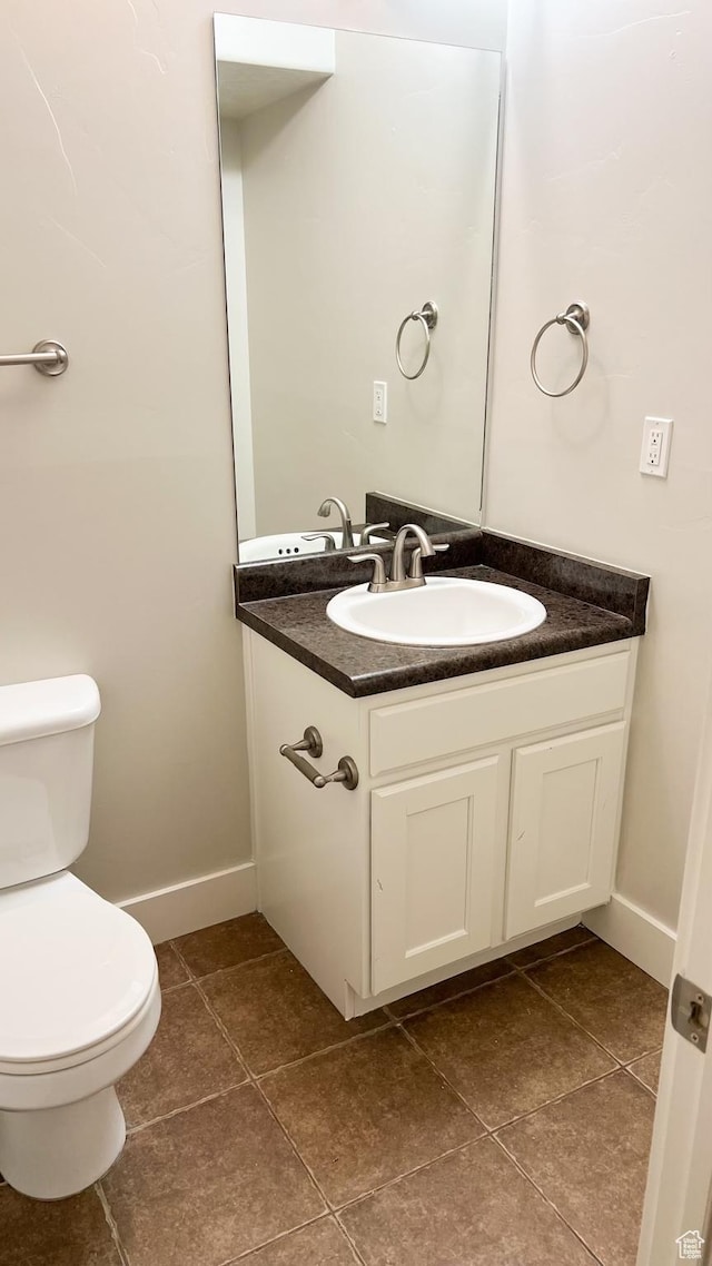 bathroom with tile patterned floors, toilet, vanity, and baseboards