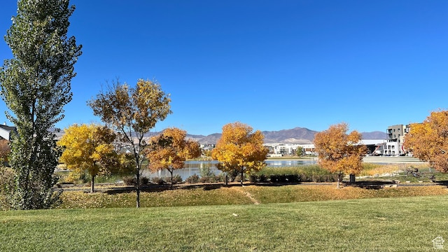 surrounding community featuring a lawn and a water and mountain view