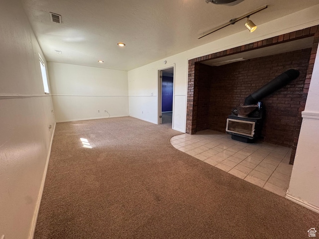 350 S 50 W, Ephraim, UT 84627 - tiled spare room featuring carpet floors, a wood stove, visible vents, and baseboards