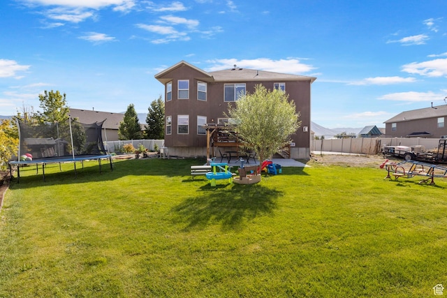 5943 N Bleeker, Stansbury Park, UT 84074 - rear view of house featuring a trampoline and a fenced backyard