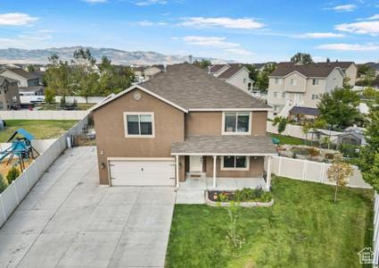 5943 N Bleeker, Stansbury Park, UT 84074 - traditional-style house featuring an attached garage, a residential view, concrete driveway, stucco siding, and a porch