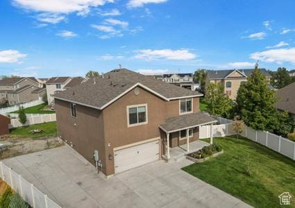 5943 N Bleeker, Stansbury Park, UT 84074 - back of house featuring a garage, a fenced backyard, concrete driveway, stucco siding, and a residential view