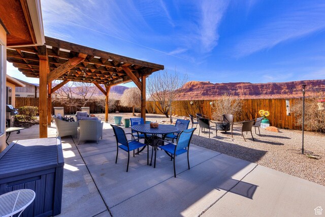 827 N Palisade Dr, Moab, UT 84532 - view of patio featuring a fenced backyard, an outdoor living space with a fire pit, outdoor dining space, and a mountain view
