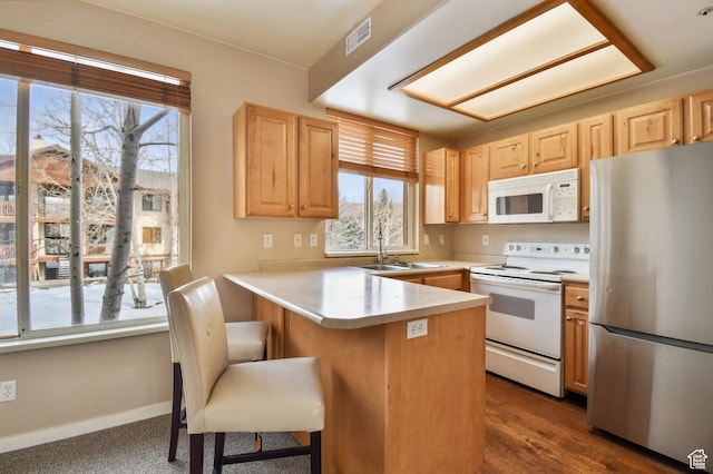 1600 Pinebrook Blvd Unit G4, Park City, UT 84098 - kitchen with white appliances, a sink, light brown cabinetry, a peninsula, and a kitchen breakfast bar