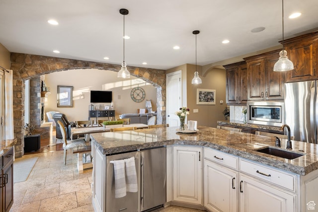 1865 S 3350 E, Heber City, UT 84032 - kitchen featuring appliances with stainless steel finishes, stone tile flooring, arched walkways, open floor plan, and recessed lighting