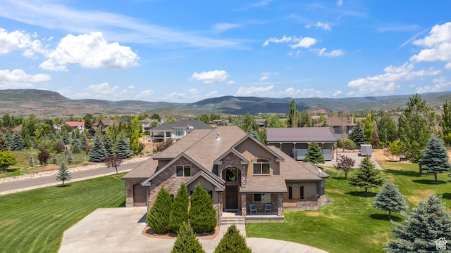 1865 S 3350 E, Heber City, UT 84032 - view of front facade featuring stone siding, concrete driveway, a mountain view, and a front yard